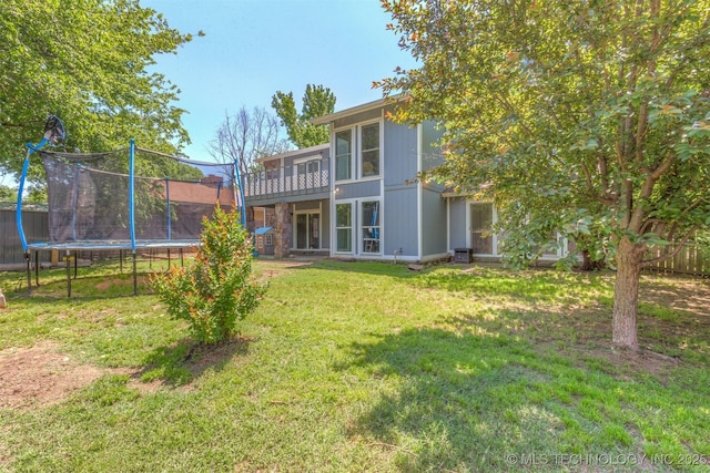 rear view of property with a trampoline