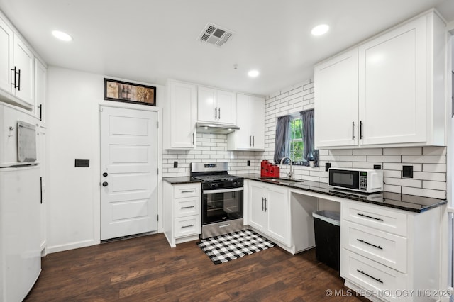 610 E 4th Ave, Bristow, OK 74010 - kitchen featuring stainless steel range with gas stovetop, white microwave, a sink, dark countertops, and recessed lighting