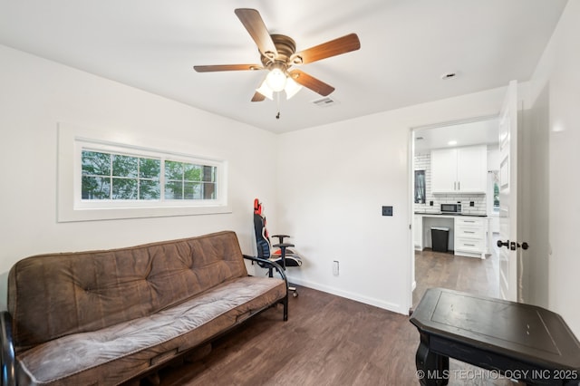 610 E 4th Ave, Bristow, OK 74010 - living room featuring dark wood-style flooring, a ceiling fan, and baseboards