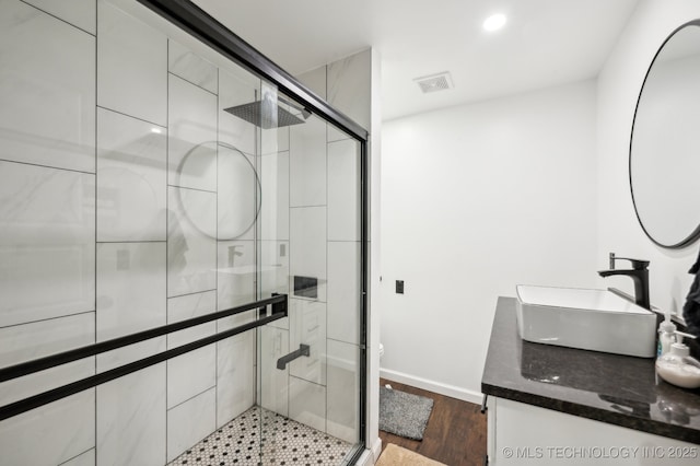 610 E 4th Ave, Bristow, OK 74010 - full bathroom featuring a stall shower, wood finished floors, double vanity, and baseboards