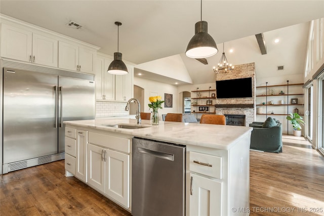 16990 S 33rd W Ave, Glenpool, OK 74033 - kitchen with appliances with stainless steel finishes, a sink, arched walkways, dark wood-type flooring, and vaulted ceiling