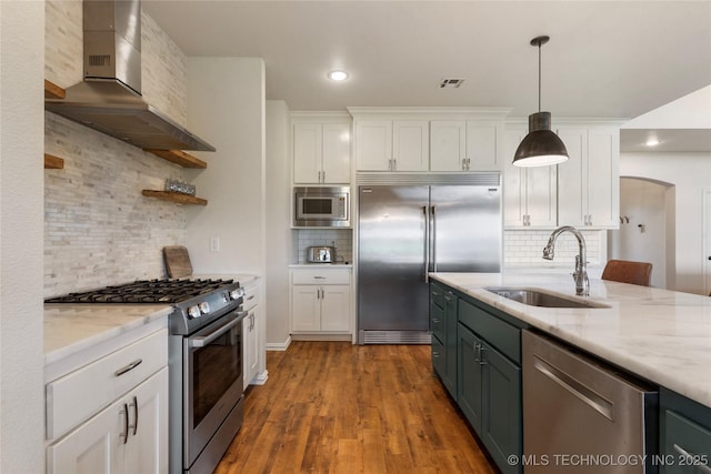 16990 S 33rd W Ave, Glenpool, OK 74033 - kitchen featuring built in appliances, white cabinets, wall chimney exhaust hood, tasteful backsplash, and light stone countertops