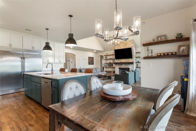 16990 S 33rd W Ave, Glenpool, OK 74033 - dining space featuring dark wood finished floors, a chandelier, a stone fireplace, and lofted ceiling
