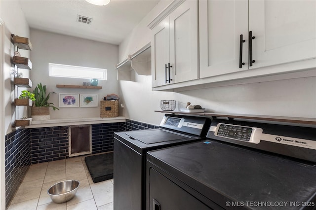 16990 S 33rd W Ave, Glenpool, OK 74033 - washroom with washing machine and clothes dryer, cabinet space, light tile patterned floors, and a wainscoted wall