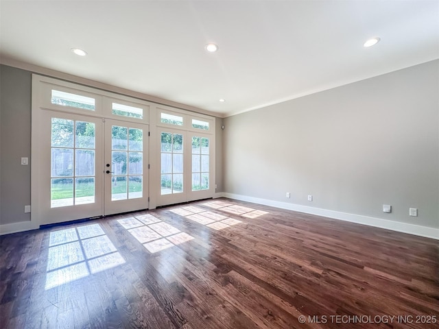 unfurnished room featuring french doors, baseboards, plenty of natural light, dark wood-style flooring, and recessed lighting