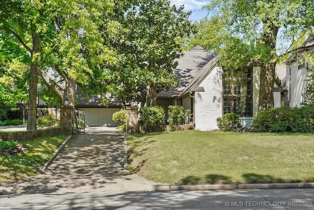 2650 S Utica Ave, Tulsa, OK 74114 - view of front facade with concrete driveway, a front yard, a shingled roof, and brick siding