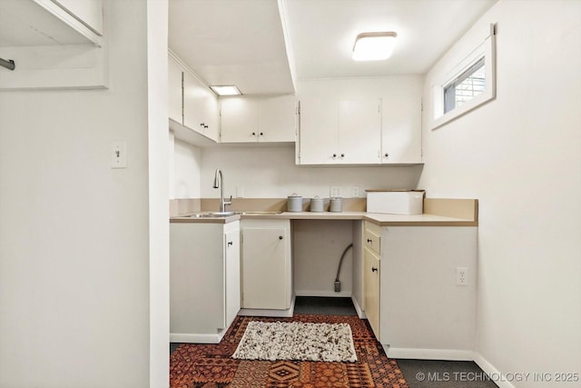 2650 S Utica Ave, Tulsa, OK 74114 - kitchen with a sink, white cabinetry, baseboards, and light countertops