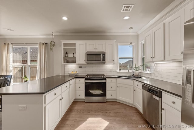 10104 S 227th E Ave, Broken Arrow, OK 74014 - kitchen featuring appliances with stainless steel finishes, a sink, a peninsula, dark countertops, and crown molding