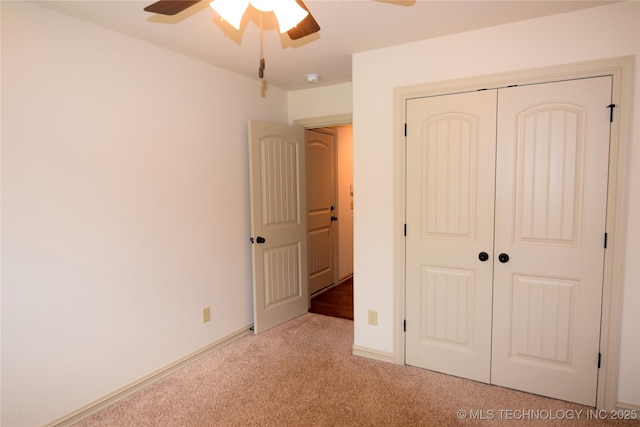 unfurnished bedroom featuring carpet flooring, a closet, ceiling fan, and baseboards