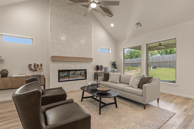 1331 N Beech St, Broken Arrow, OK 74012 - living room featuring high vaulted ceiling, ceiling fan, light wood-style flooring, a tiled fireplace, and recessed lighting