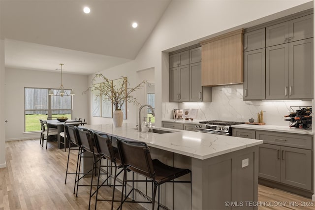 1331 N Beech St, Broken Arrow, OK 74012 - kitchen featuring a sink, gray cabinets, stainless steel gas range, vaulted ceiling, and light stone countertops