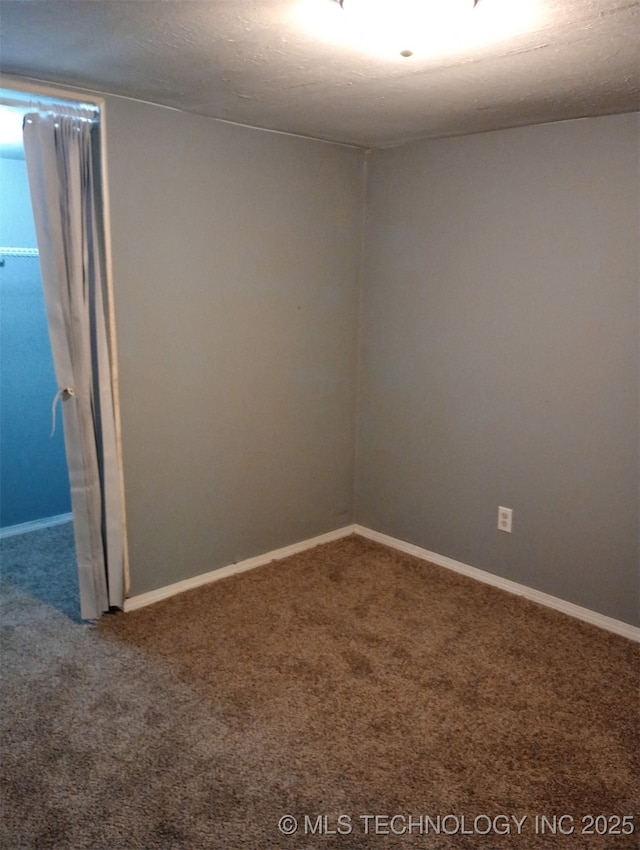 unfurnished room with carpet flooring and baseboards