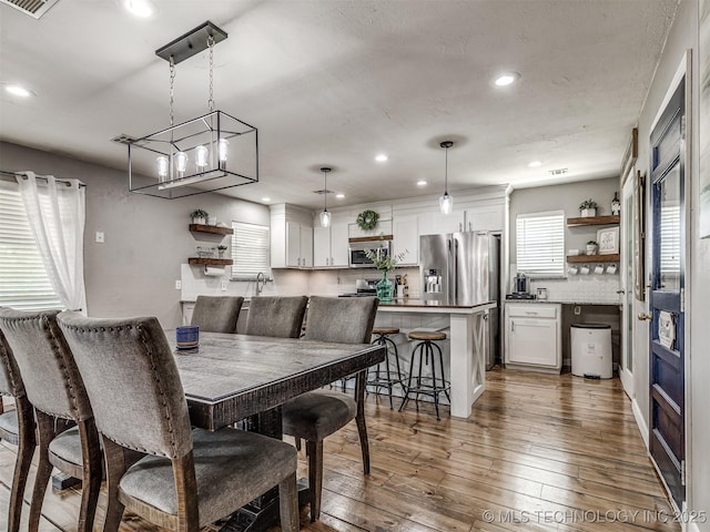 dining space featuring recessed lighting, wood-type flooring, and a chandelier