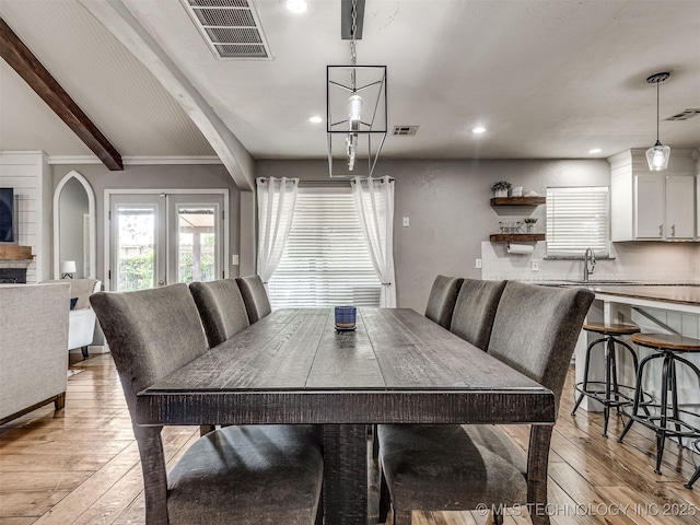 dining room featuring light wood finished floors, beam ceiling, and recessed lighting