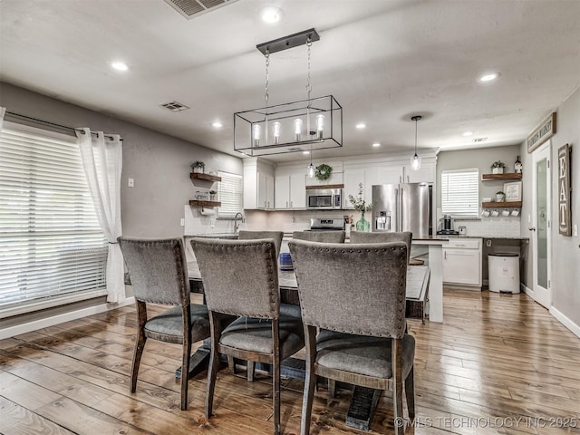 kitchen with open shelves, stainless steel appliances, white cabinets, hardwood / wood-style floors, and recessed lighting