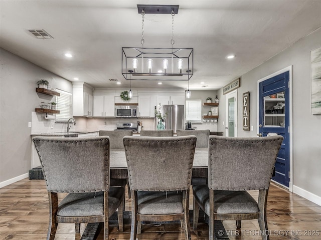 dining area featuring wood finished floors, recessed lighting, and baseboards