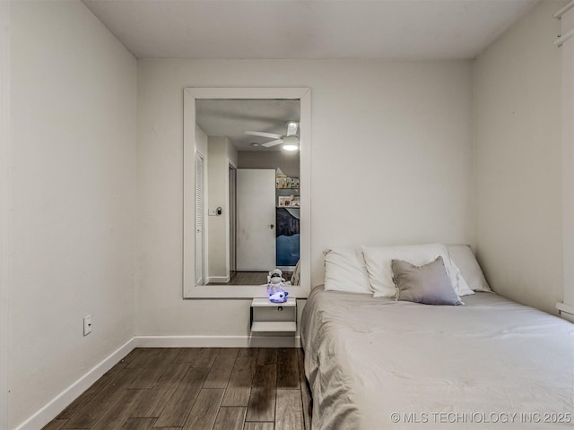 bedroom with dark wood-style flooring and baseboards