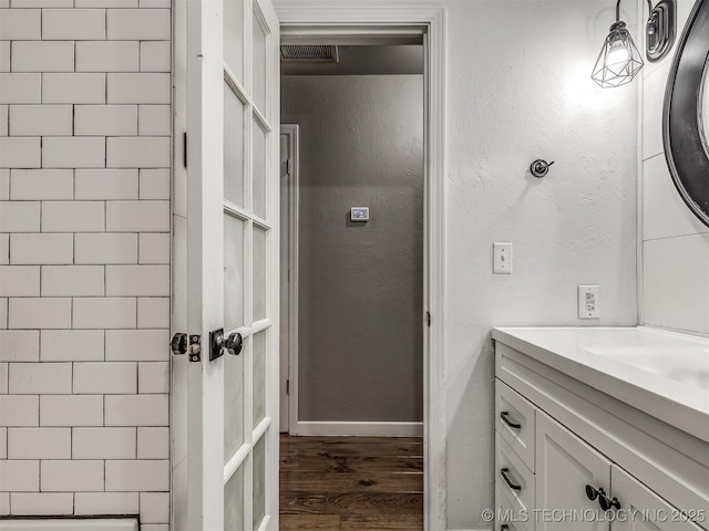 bathroom with wood finished floors, vanity, and baseboards