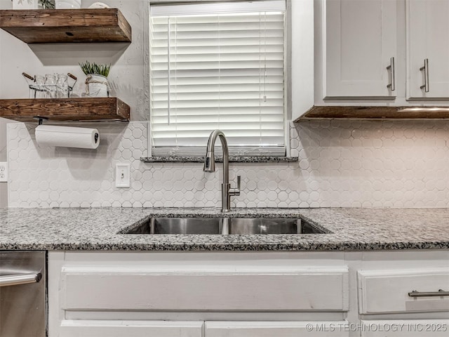 kitchen featuring a sink, open shelves, tasteful backsplash, and light stone countertops