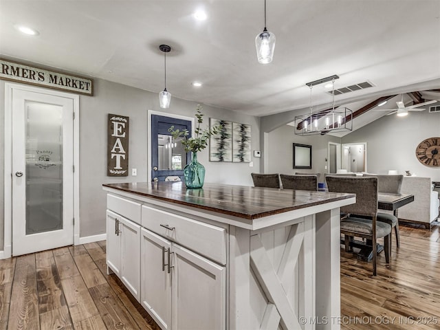kitchen with wooden counters, white cabinetry, dark wood finished floors, open floor plan, and recessed lighting