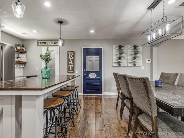 dining area featuring dark wood-style floors, baseboards, recessed lighting, and a chandelier