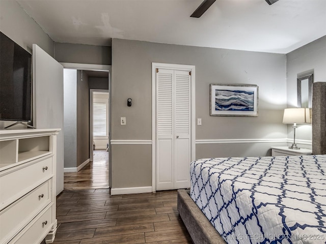 bedroom featuring dark wood finished floors, a closet, baseboards, and ceiling fan