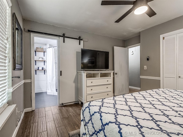 bedroom with wood finish floors, baseboards, a closet, ceiling fan, and ensuite bath