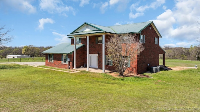 2750 Enterprise, Lone Grove, OK 73401 - view of front of property with brick siding, a front lawn, central air condition unit, and metal roof