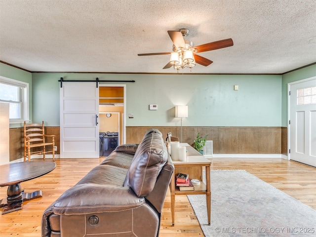 3931 S Oswego Ave, Tulsa, OK 74135 - living area featuring a textured ceiling, wainscoting, a ceiling fan, plenty of natural light, and wood finished floors