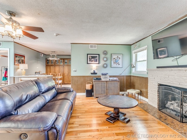 3931 S Oswego Ave, Tulsa, OK 74135 - living area featuring wood-type flooring, wainscoting, a textured ceiling, ceiling fan, and wood walls