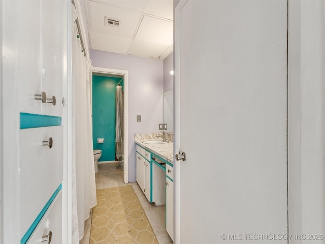 3931 S Oswego Ave, Tulsa, OK 74135 - bathroom with toilet, vanity, and a drop ceiling