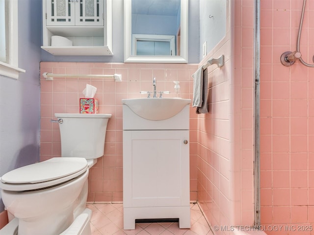 3931 S Oswego Ave, Tulsa, OK 74135 - bathroom with tile walls, vanity, toilet, and tile patterned floors