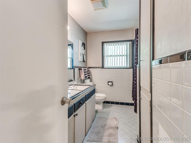 3931 S Oswego Ave, Tulsa, OK 74135 - bathroom featuring tile walls, toilet, tile patterned floors, and vanity