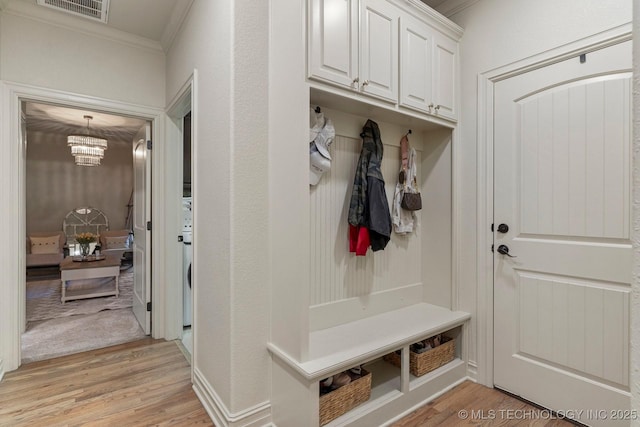 9475 E 107th Pl S, Bixby, OK 74133 - mudroom with crown molding, light wood-style flooring, and a chandelier