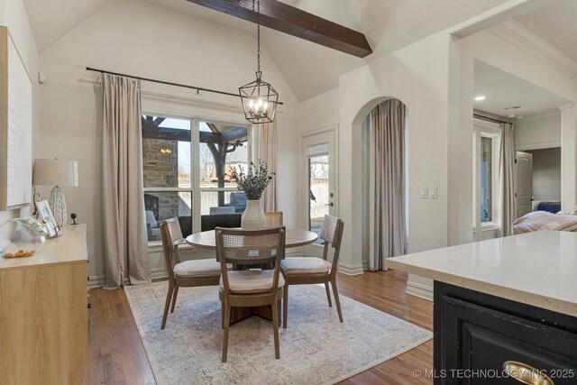 9475 E 107th Pl S, Bixby, OK 74133 - dining space featuring a chandelier, light wood-style floors, beamed ceiling, high vaulted ceiling, and baseboards