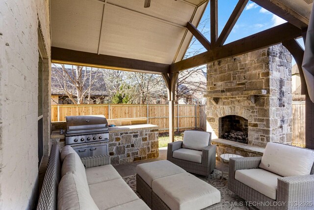 9475 E 107th Pl S, Bixby, OK 74133 - view of patio featuring grilling area, a fenced backyard, an outdoor living space with a fireplace, and an outdoor kitchen
