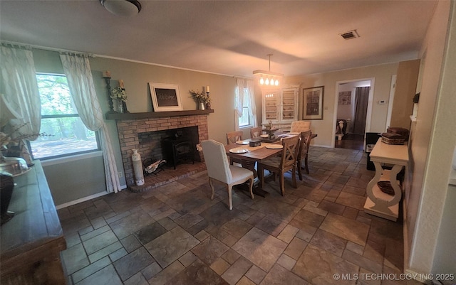 5328 Monroe Rd, Kingston, OK 73439 - dining area with stone tile flooring, a wood stove, baseboards, and a chandelier