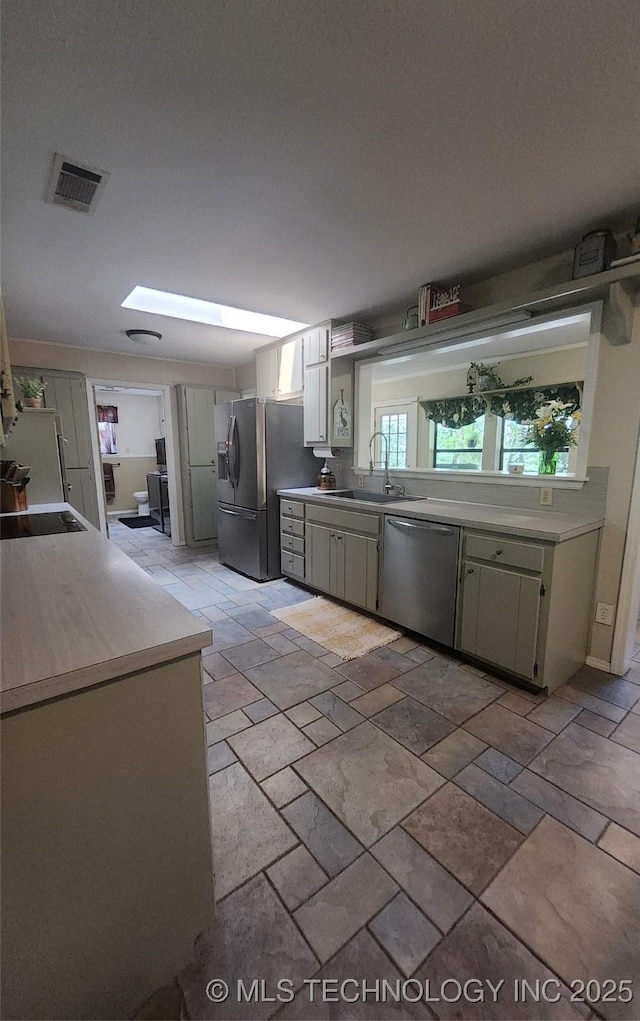 5328 Monroe Rd, Kingston, OK 73439 - kitchen with appliances with stainless steel finishes, a sink, light countertops, and stone tile floors