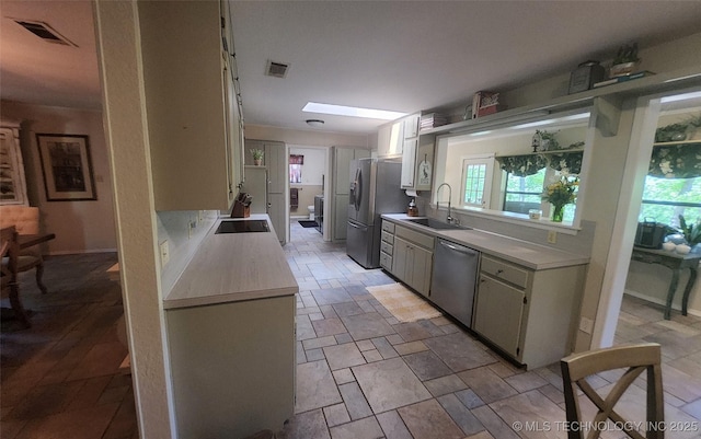 5328 Monroe Rd, Kingston, OK 73439 - kitchen with stainless steel appliances, a sink, light countertops, and light stone finish floors