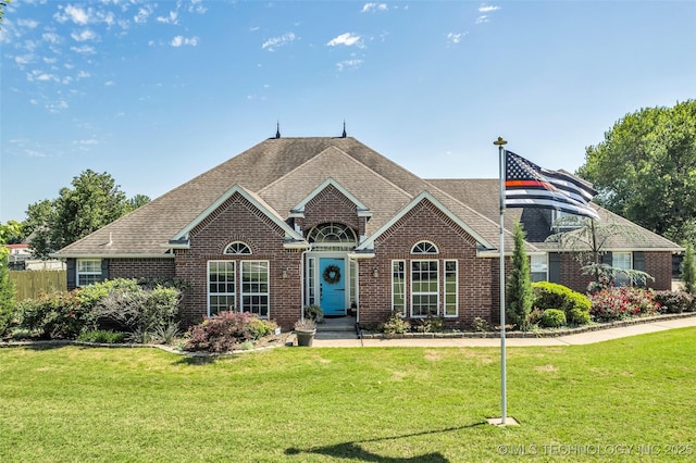 view of front of house featuring brick siding and a shingled roof