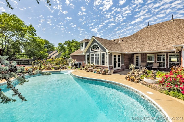 view of swimming pool with french doors, a patio area, and fence