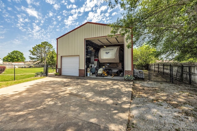 view of outdoor structure with fence, an outdoor structure, a gate, and driveway