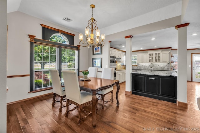 dining area with ornate columns, light wood-style floors, a chandelier, recessed lighting, and baseboards