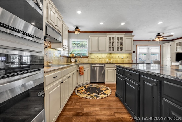 kitchen featuring stainless steel appliances, ceiling fan, dark cabinets, healthy amount of natural light, and recessed lighting