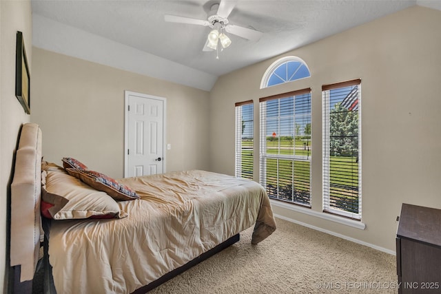 bedroom featuring vaulted ceiling, carpet floors, baseboards, and a ceiling fan