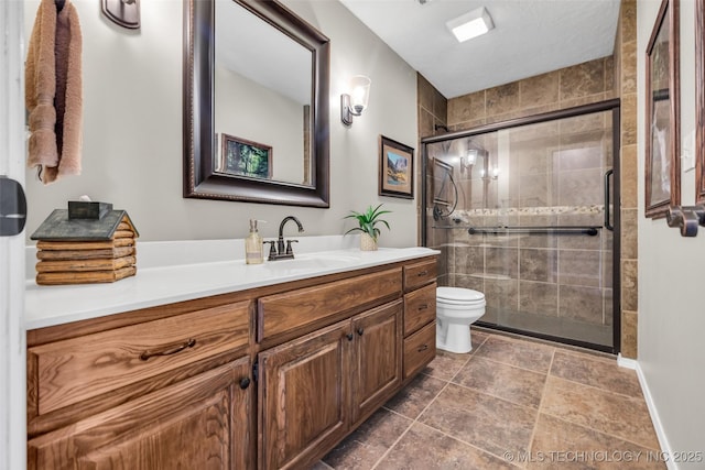 full bathroom featuring toilet, vanity, and a shower stall