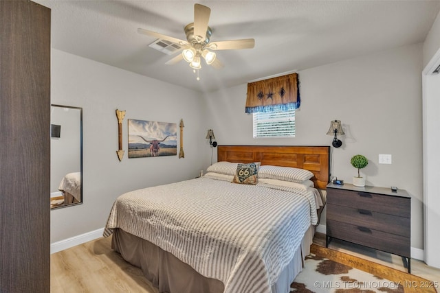 bedroom featuring light wood finished floors, baseboards, and a ceiling fan