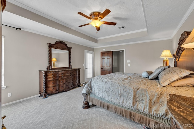 bedroom with a tray ceiling, carpet flooring, ornamental molding, ceiling fan, and baseboards