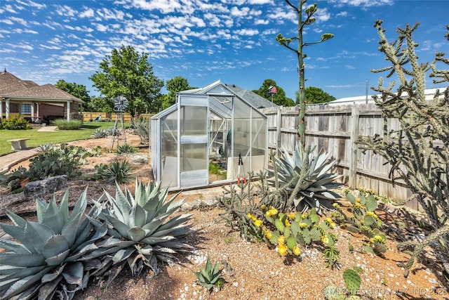 view of greenhouse featuring fence