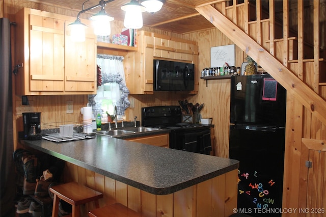 6363 S Brewer Rd, Kiowa, OK 74553 - kitchen featuring black appliances, a sink, dark countertops, wood walls, and a peninsula